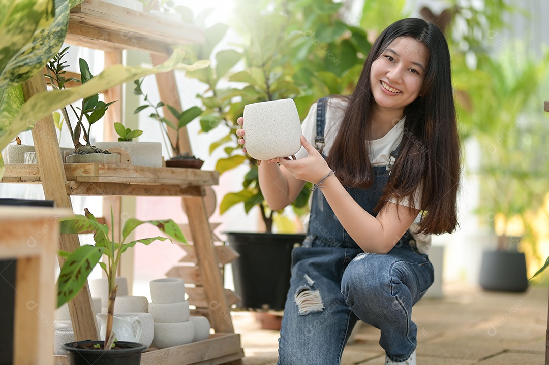 Jovem mulher plantando e cuidando de árvores em estufas, plantando e cuidando de equipamentos, pequenas empresas.