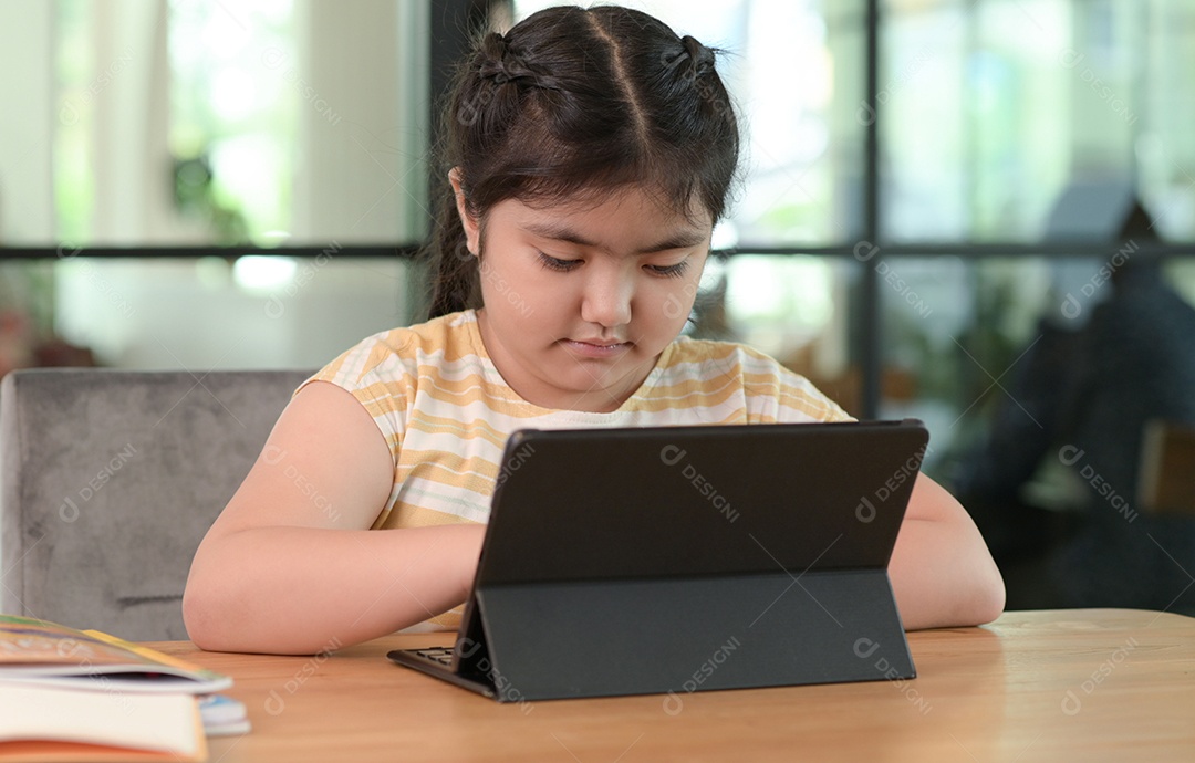 Menina asiática estão dando aulas em casa, estudam on-line em casa, as meninas estão entediadas e cansadas de estudar.