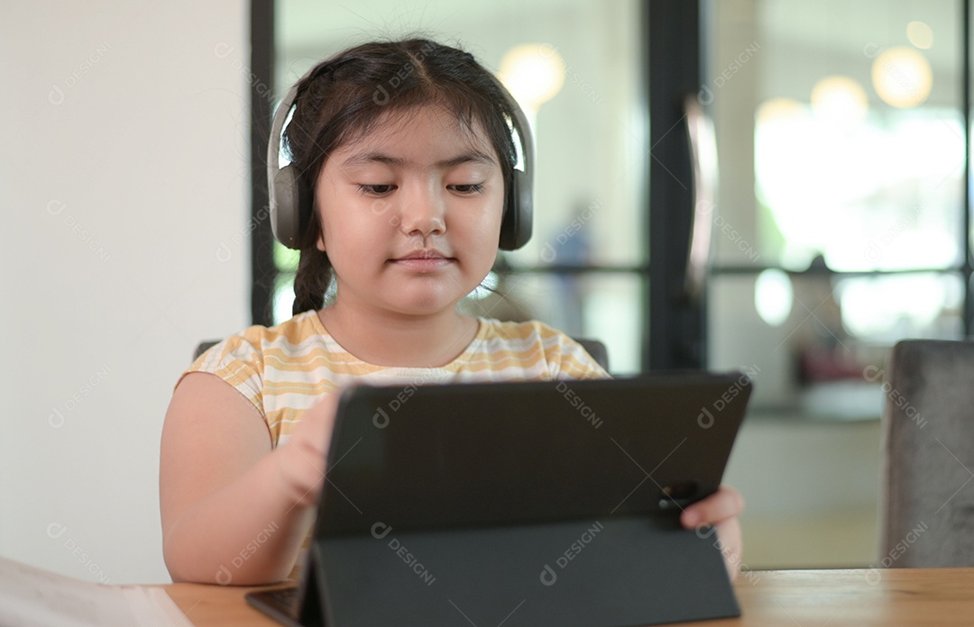 Menina asiática estão dando aulas em casa, estudam on-line em casa, as meninas estão entediadas e cansadas de estudar.