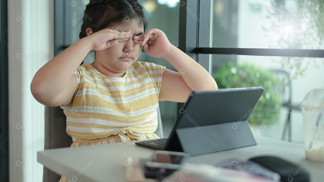 Menina asiática estão dando aulas em casa, estudam on-line em casa, as meninas estão entediadas e cansadas de estudar.