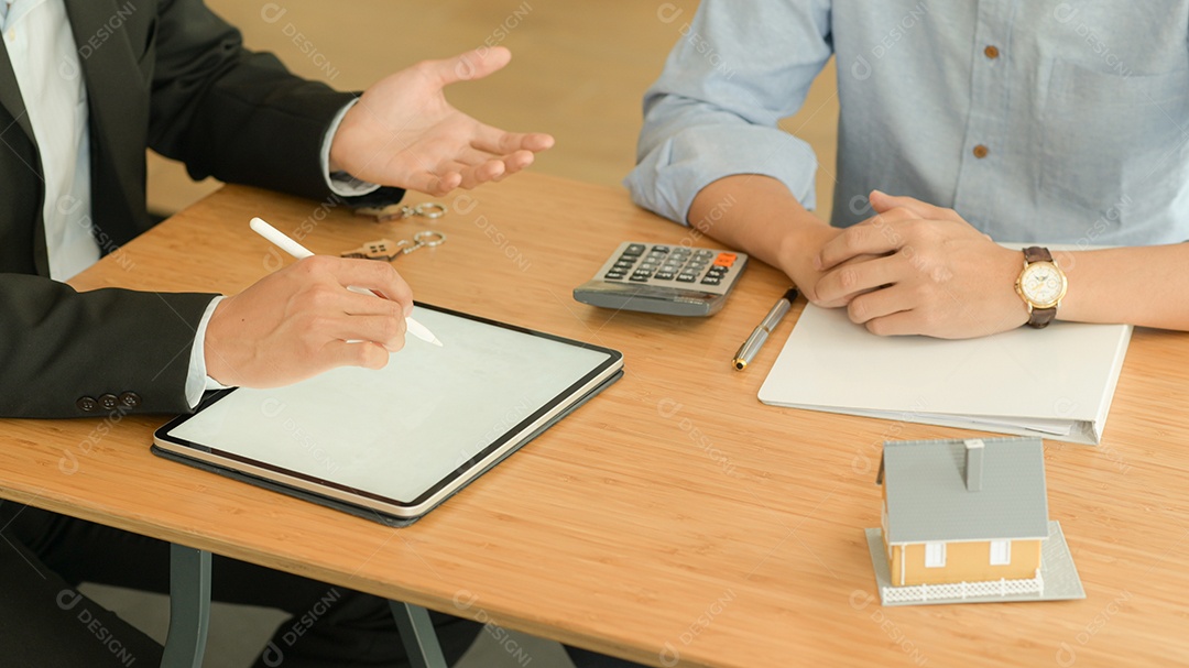 Agentes de seguros com tablet estão introduzindo programas de seguro imobiliário para o cliente.