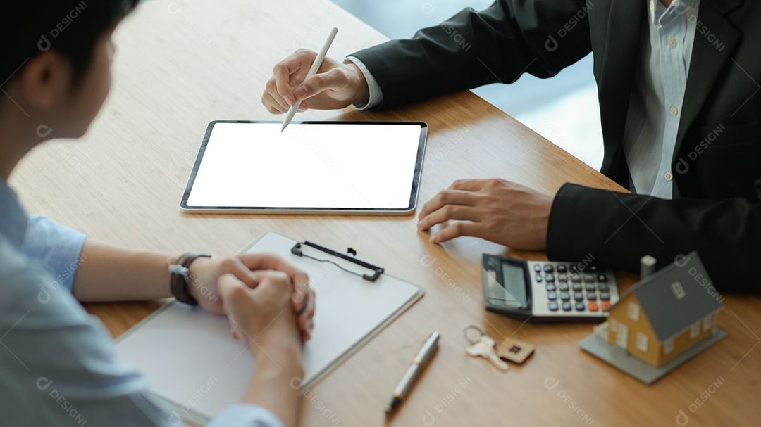 Agentes de seguros com tablet estão introduzindo programas de seguro imobiliário para o cliente.