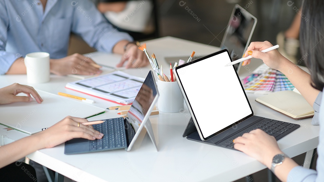 Equipe de designer gráfico usa laptops para projetar novos projetos para clientes.