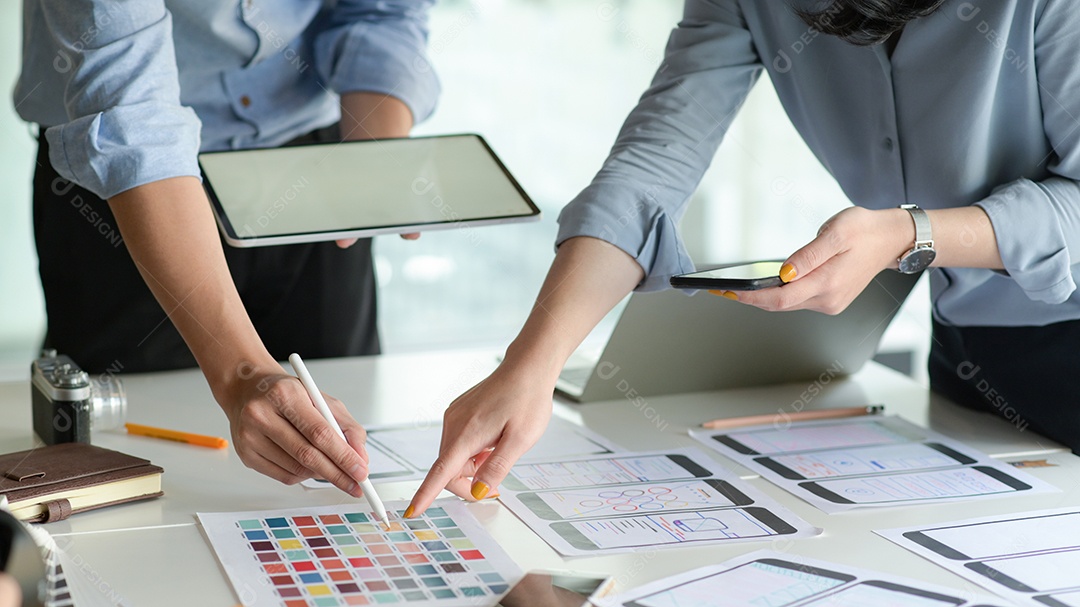 A equipe de design UX com tablet planeja desenvolver um protótipo de aplicativo para smartphone.