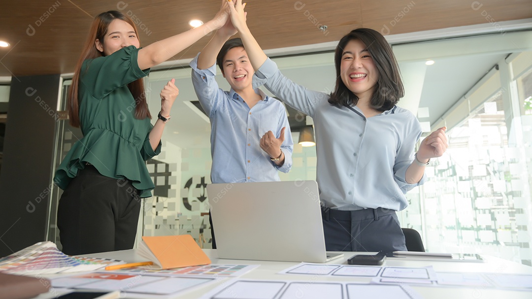 A equipe de negócios levantou as mãos para mostrar sua alegria após a videoconferência da reunião com os clientes atingindo seus objetivos.
