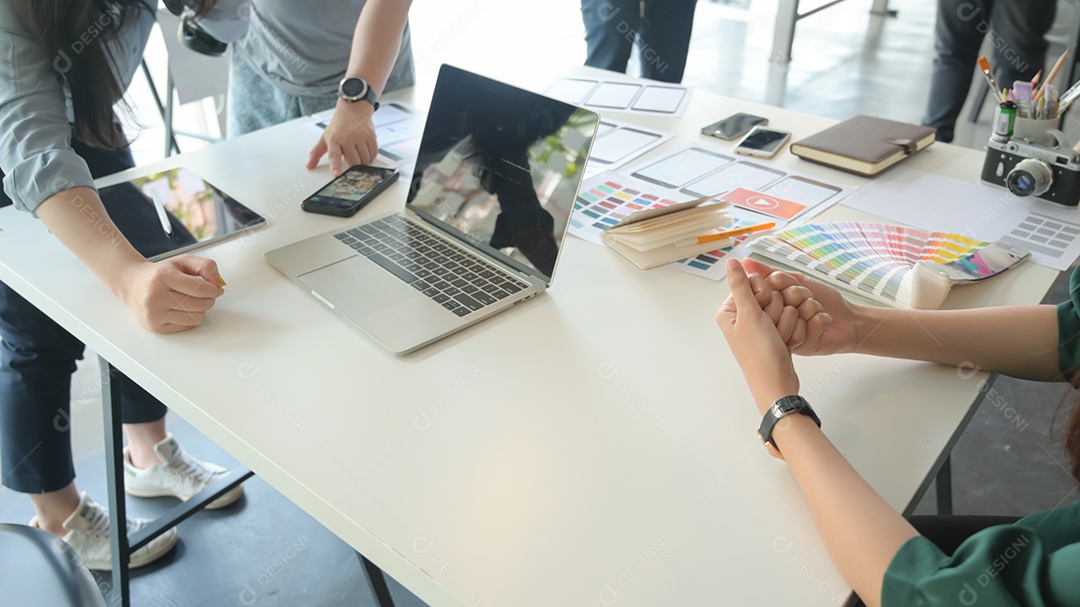 A equipe de UX está projetando um aplicativo para smartphones com laptop em um escritório moderno.