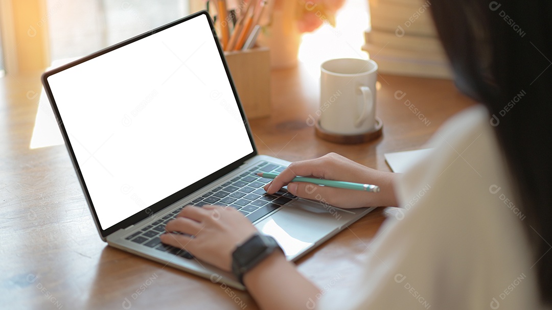 Mulher de negócio jovem estão usando laptop de tela em branco com xícara de café no escritório moderno.