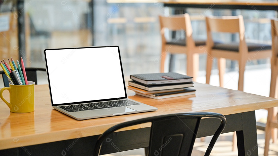 Foto recortada de Laptop com notebooks e estacionário em uma mesa de madeira em um escritório moderno.