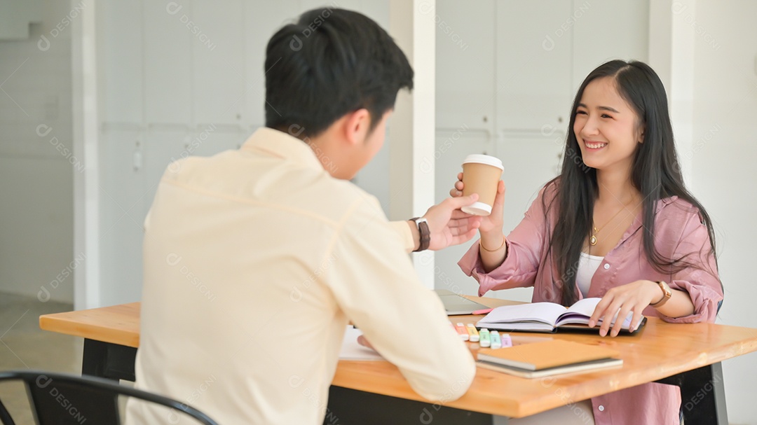 Foto de homens dando café para mulheres enquanto estressados ​​lendo livros para preparação para exames.