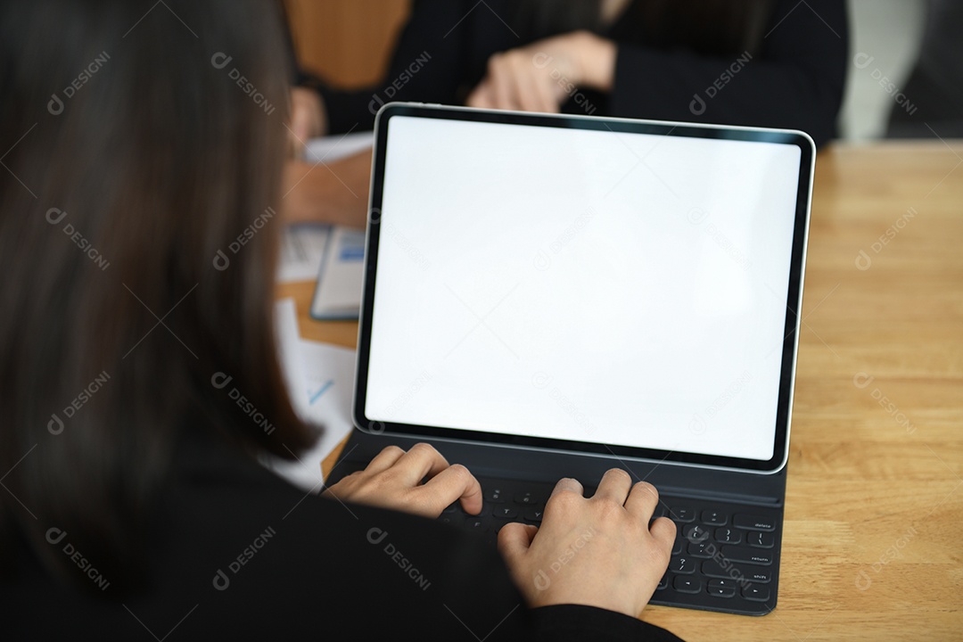 Foto recortada de uma funcionária digitando um teclado em um laptop com uma tela branca em branco.