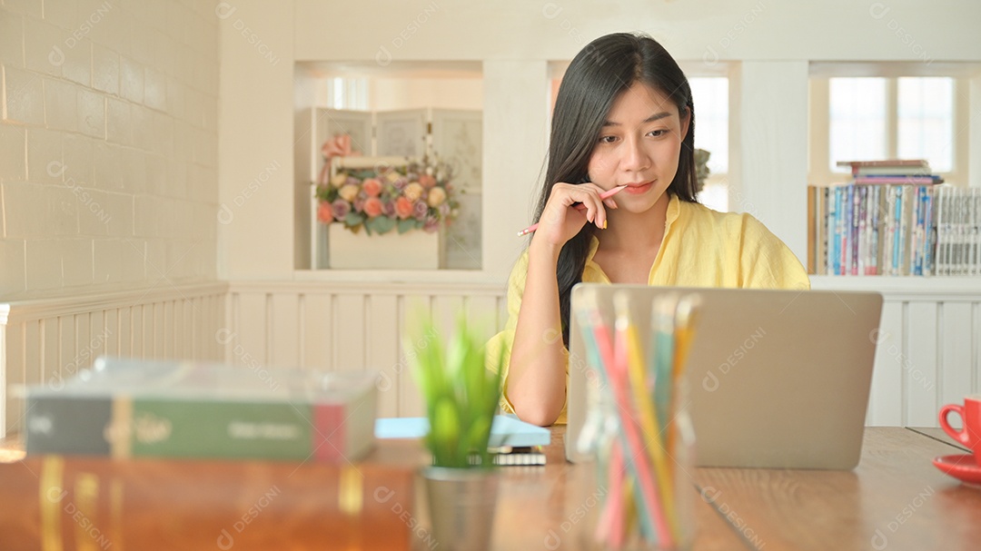 Mulher asiática com um laptop trabalhando em casa. Para evitar a propagação do coronavírus.