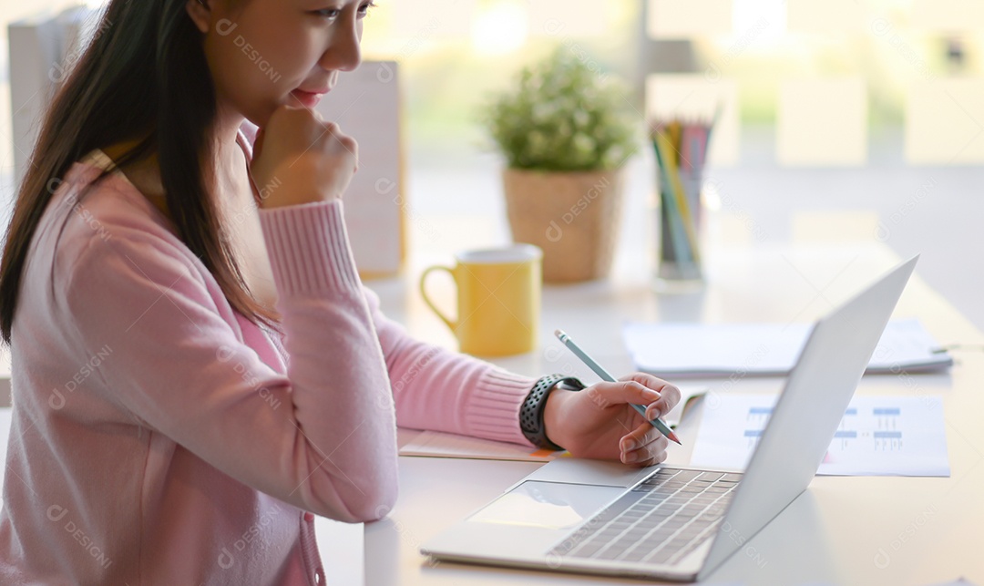 Tiro recortado de mulher jovem usam laptop no escritório pessoal moderno.