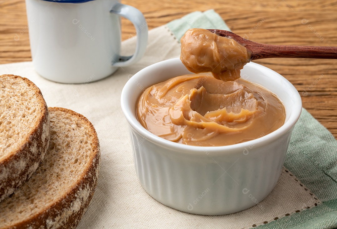 Doce de leite, doce de leite cremoso tradicional brasileiro sobre mesa de madeira.
