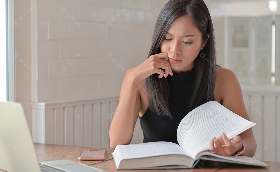 Mulher jovem estão lendo livros para o exame de admissão à universidade na sala de estar em casa.