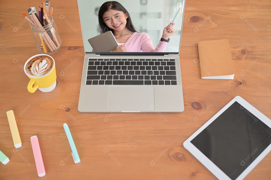 Professora em uma tela de laptop com um tablet e estacionária em uma mesa de madeira, conceito de ensino de livros on-line.