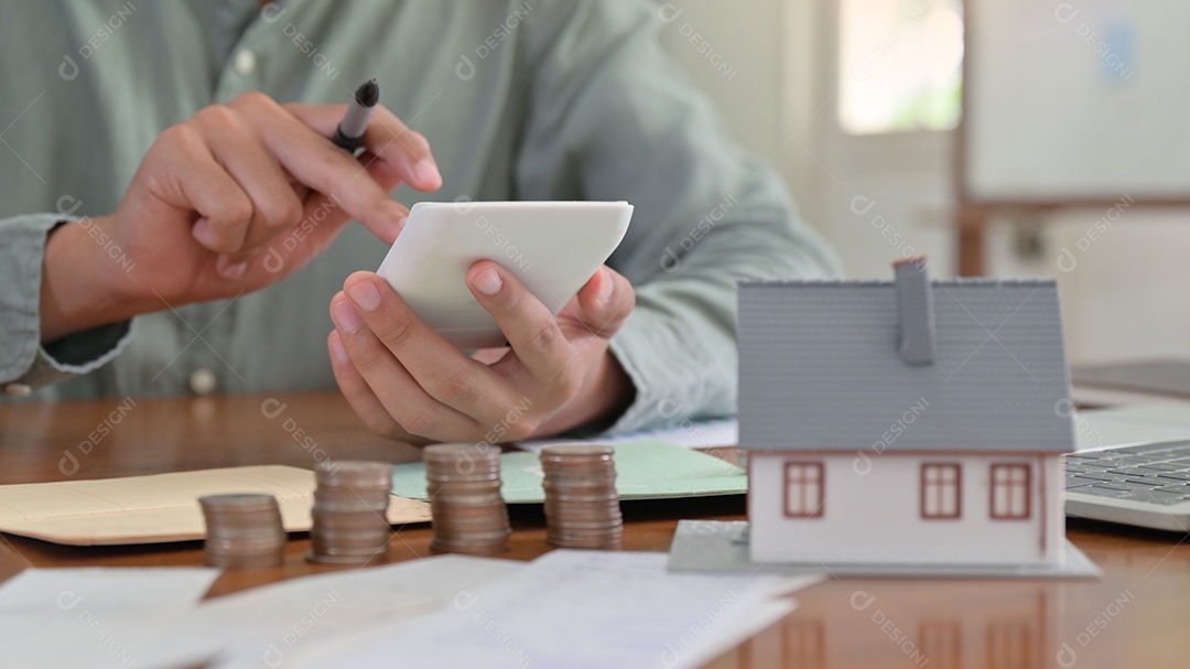 Mão está usando a calculadora para calcular as despesas domésticas.