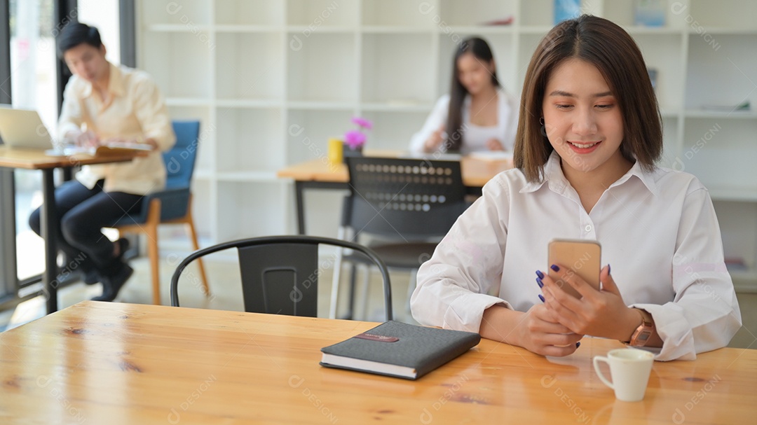 Mulher usando smartphone no Café. Elas sentam em distanciamento social.