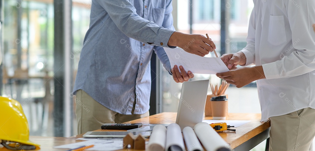 Arquitetos e empreiteiros apertam as mãos para trabalhar.