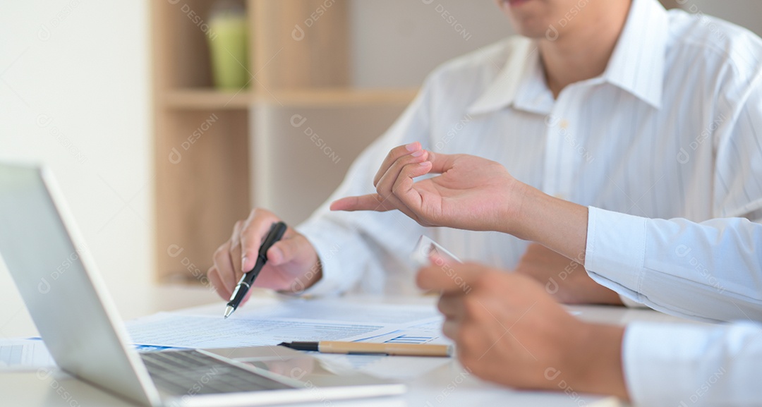 Dois jovens trocaram ideias com apontar uma caneta no gráfico e um laptop.