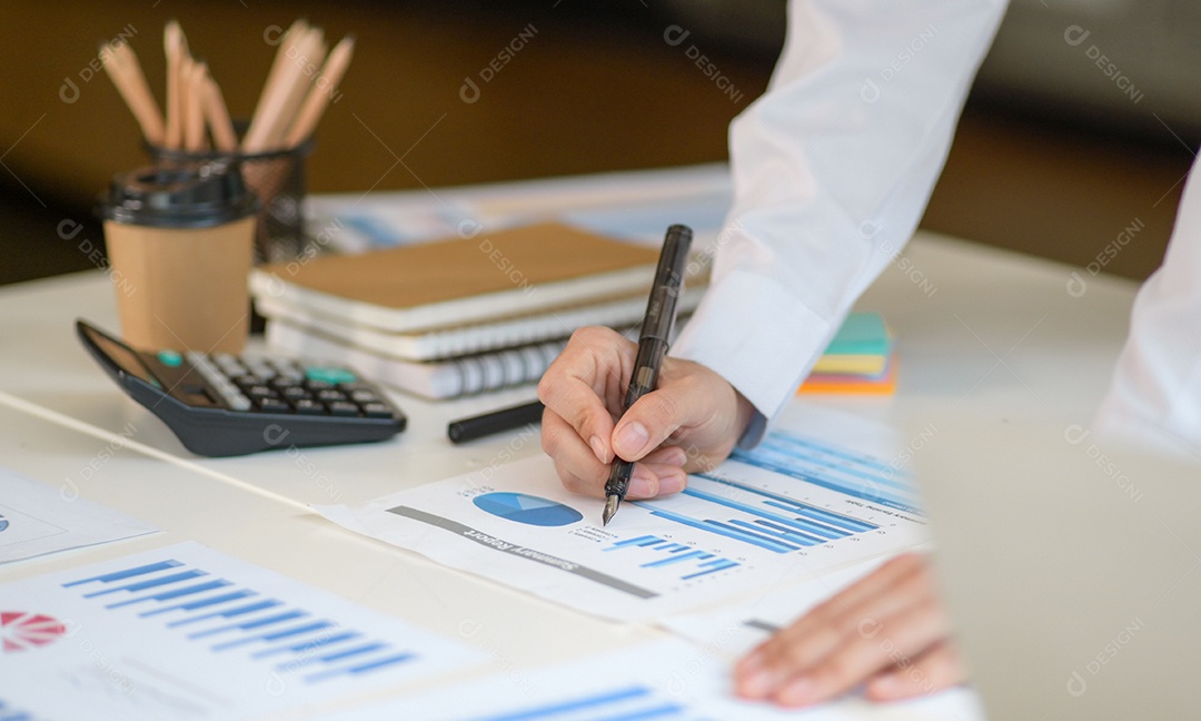 Menina com uma caneta apontando para o gráfico para analisar dados.