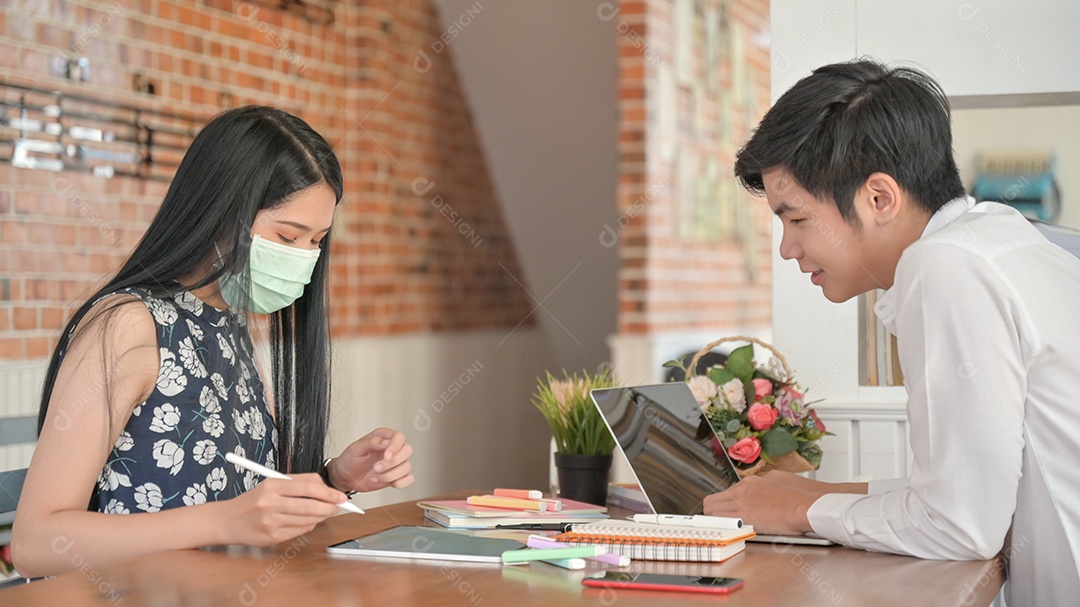 Mulher vestindo uma máscara e jovem procurando informações de laptop e tablet, eles são distância social.