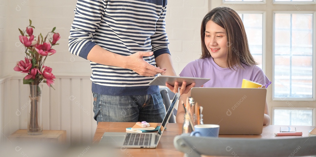 Homens e mulheres com tablets e laptop estão trocando ideias.