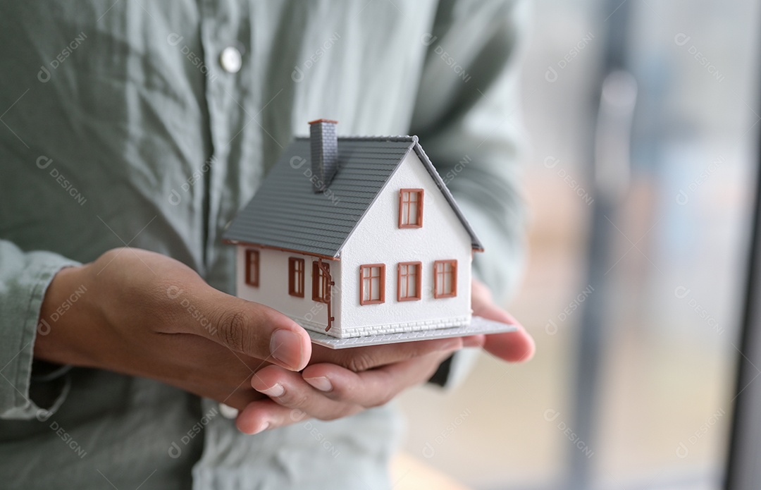 pessoa segurando uma casa modelo na mão. Para conceitos imobiliários.