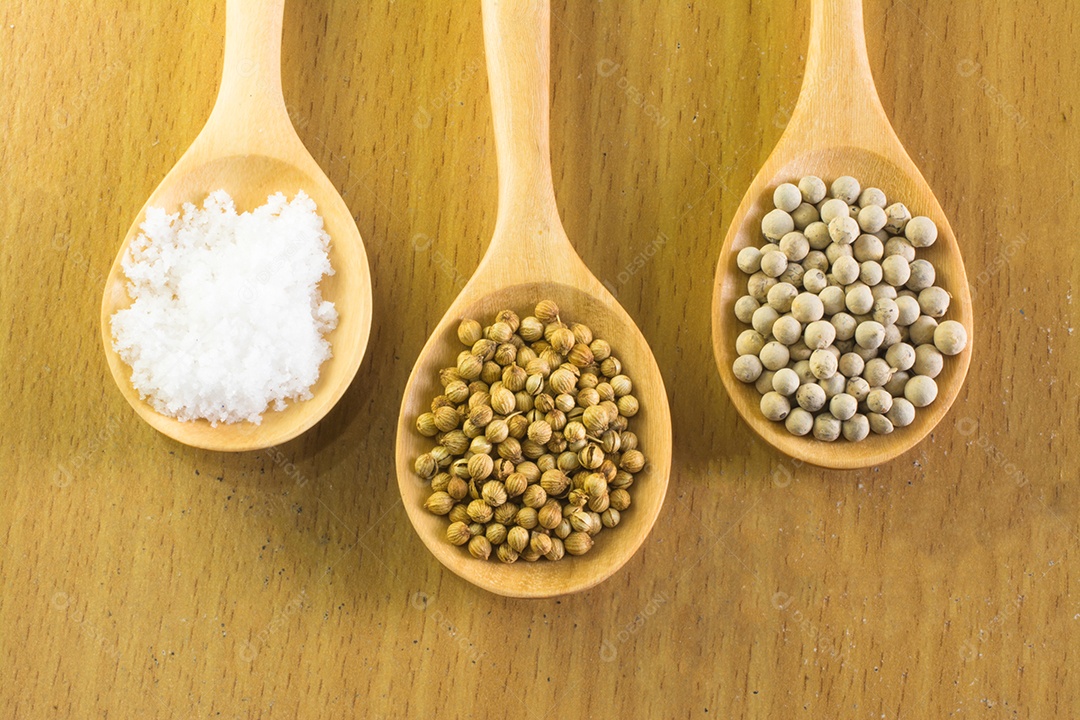 sementes de coentro sementes de pimenta branca e sal em colher de pau