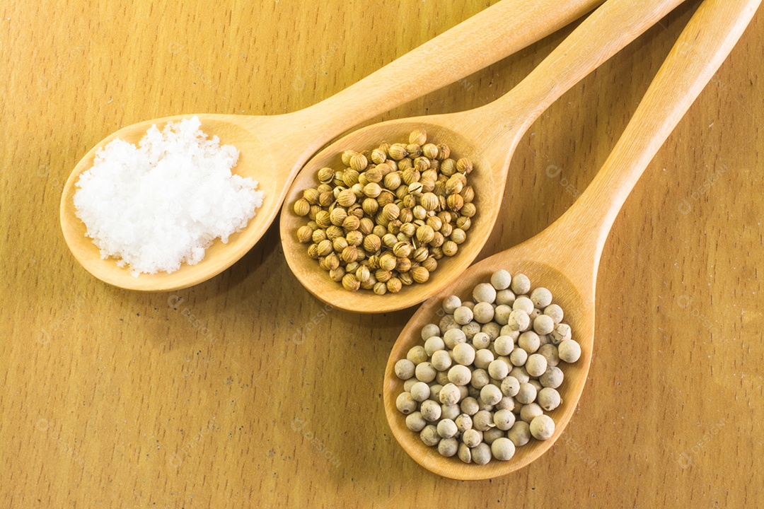 sementes de coentro sementes de pimenta branca e sal em colher de pau