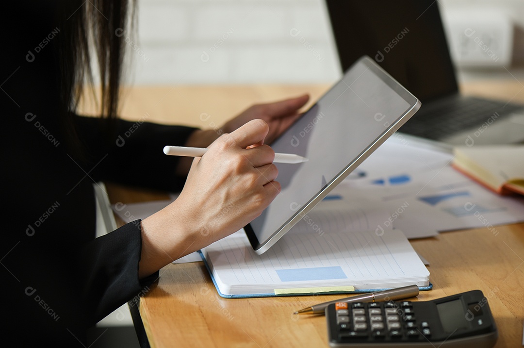 Executivos do sexo feminino estão usando uma caneta de gravação no tablet.