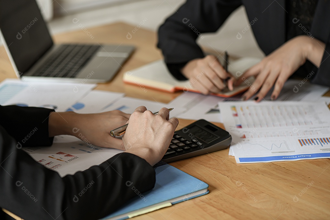 Mulheres de negócios da equipe usam caneta, calculadora estão planejando um plano de marketing para melhorar a qualidade do trabalho da organização no futuro.