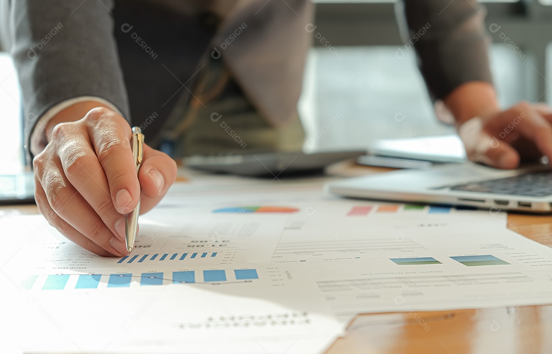 Empresários usam caneta, laptop e celular estão planejando um plano de marketing para melhorar a qualidade do trabalho da organização no futuro.