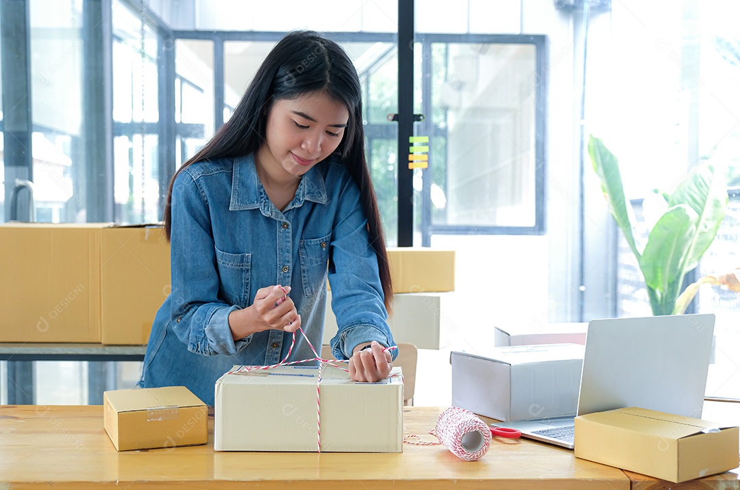 Adolescentes estão embalando os produtos na caixa e usando uma corda para entregar aos clientes.