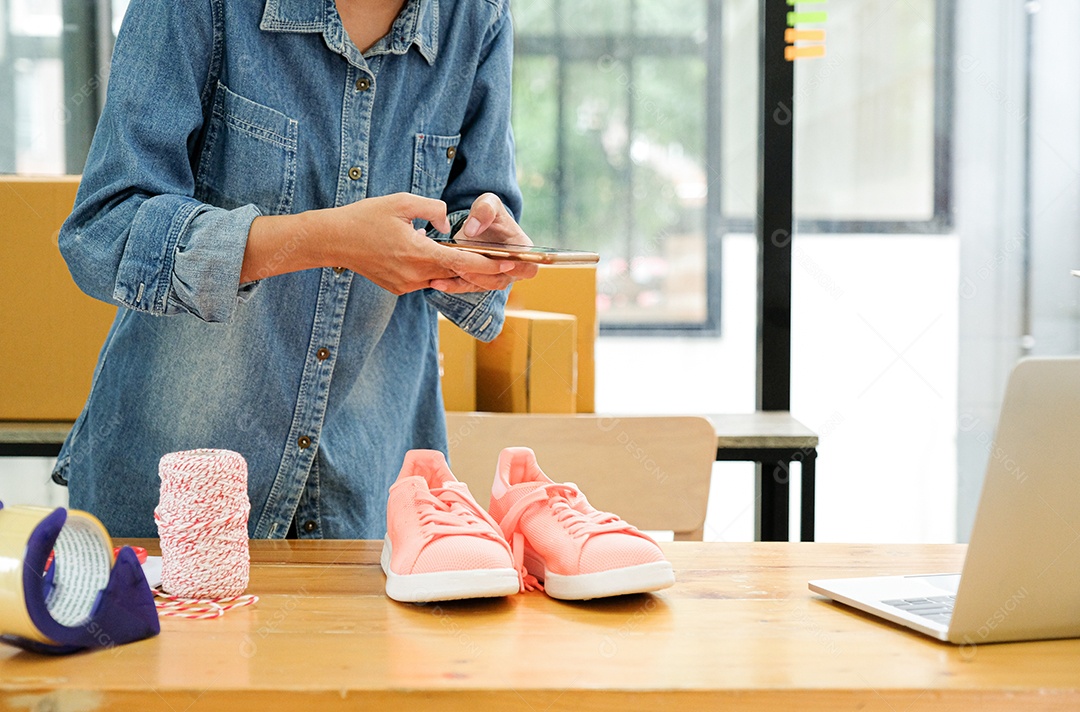 Vendedores on-line usam o celular para tirar fotos dos sapatos enviados aos clientes.