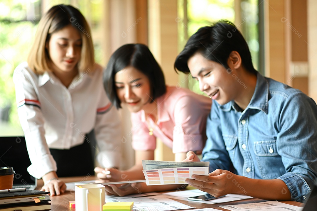 Equipe de designer gráfico está trabalhando no escritório. Eles usam laptop e tablet.