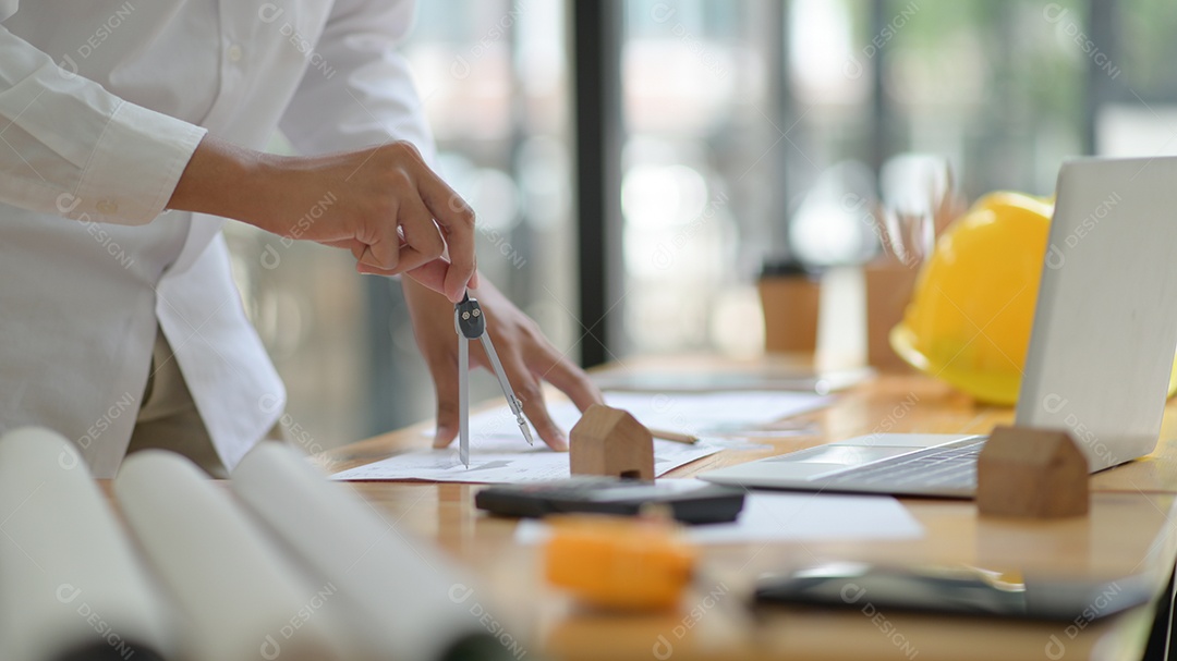 O arquiteto está projetando a construção. Ele elabora a planta baixa para apresentar ao cliente.