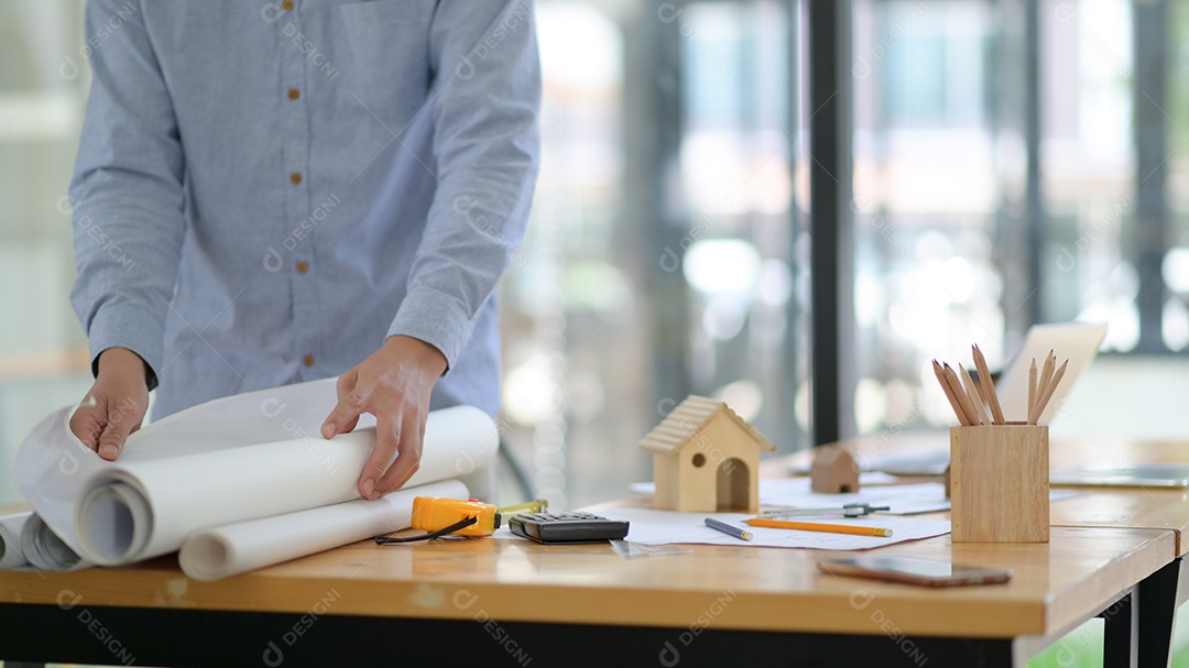 Arquiteto está coletando o plano de construção para apresentar ao cliente.