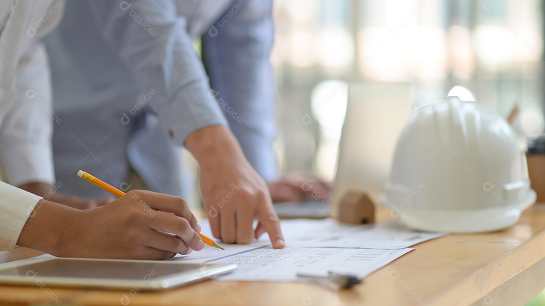 O arquiteto está projetando a construção. Ele elabora a planta baixa para apresentar ao cliente.