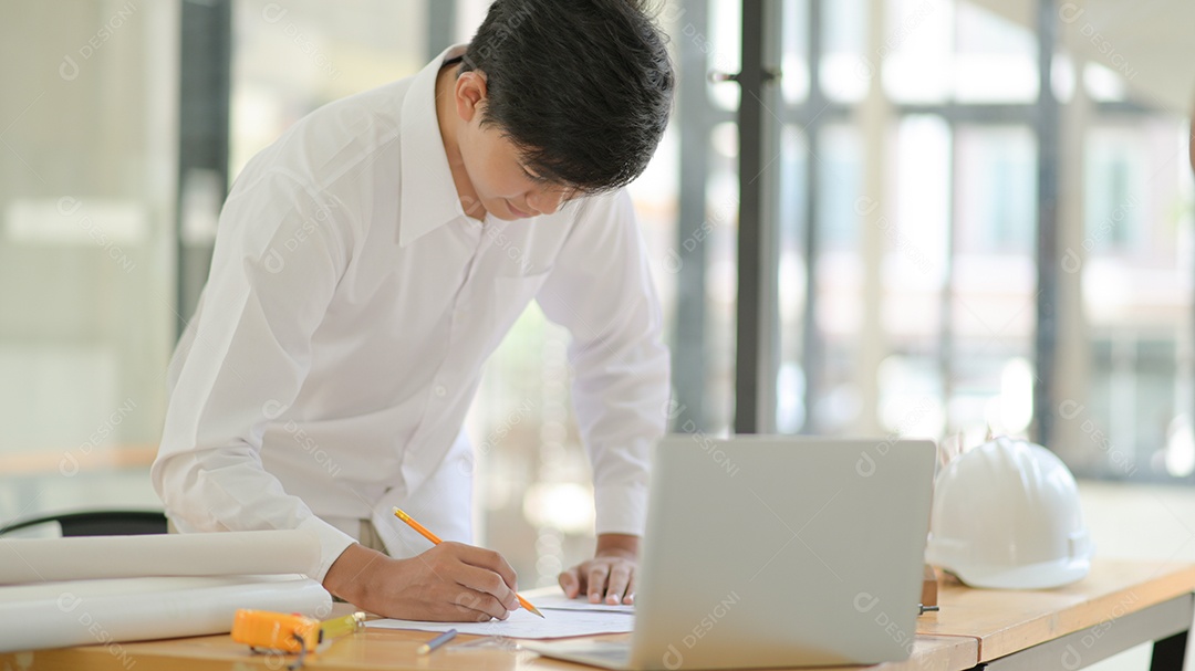 Arquiteto usou um lápis para desenhar no plano e planejar a construção do edifício para o cliente.
