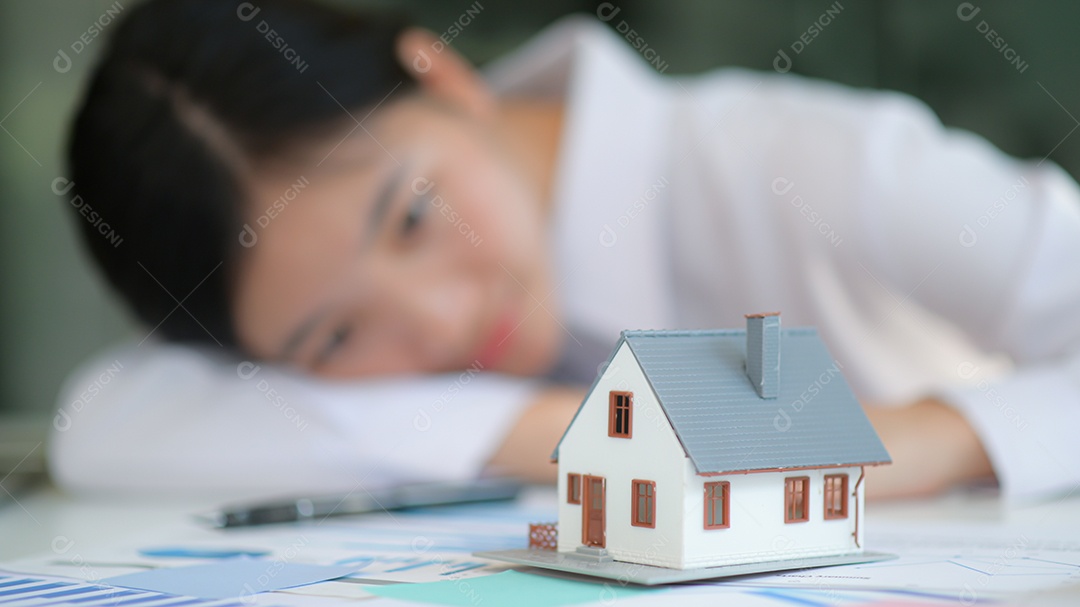 Conceito imobiliário, casa modelo frontal com garota no fundo olha em casa. Ela sonhava em comprar uma casa.