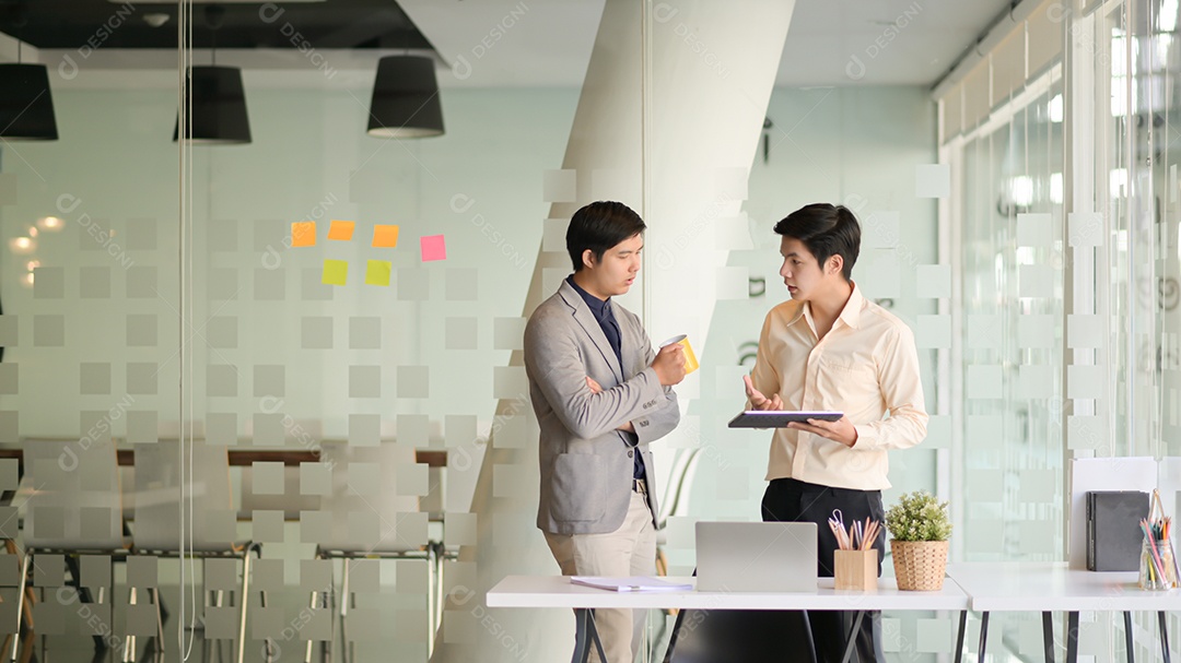 Dois jovens empresários estão planejando trabalhar para o próximo ano em um escritório moderno.