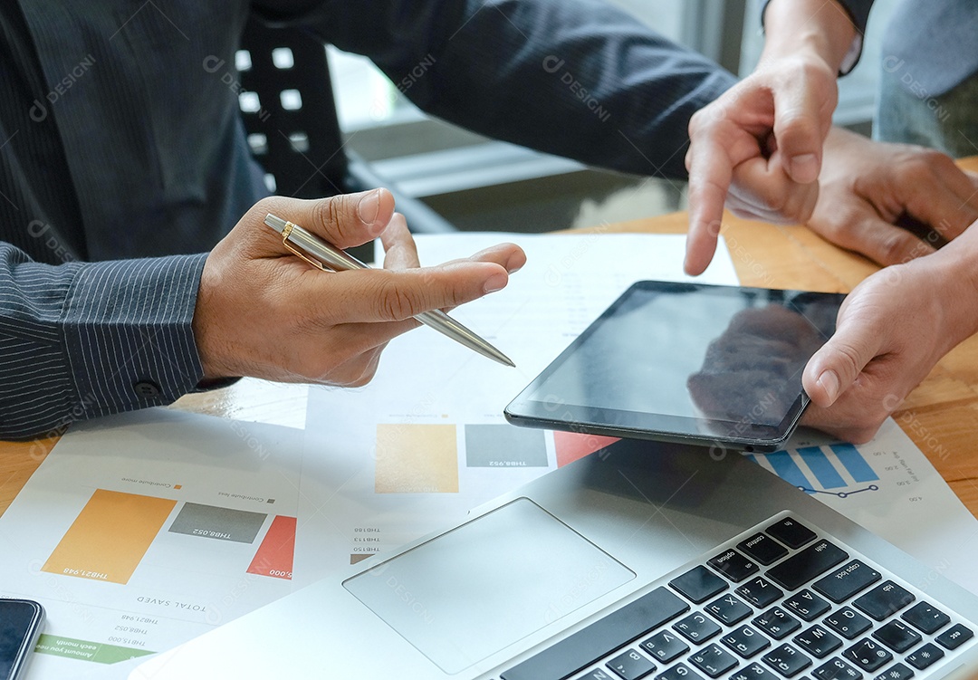 Equipe de gerenciamento de negócios está resumindo o trabalho no escritório. Empresários usam tablet e laptop. Gráficos de dados colocados sobre a mesa.