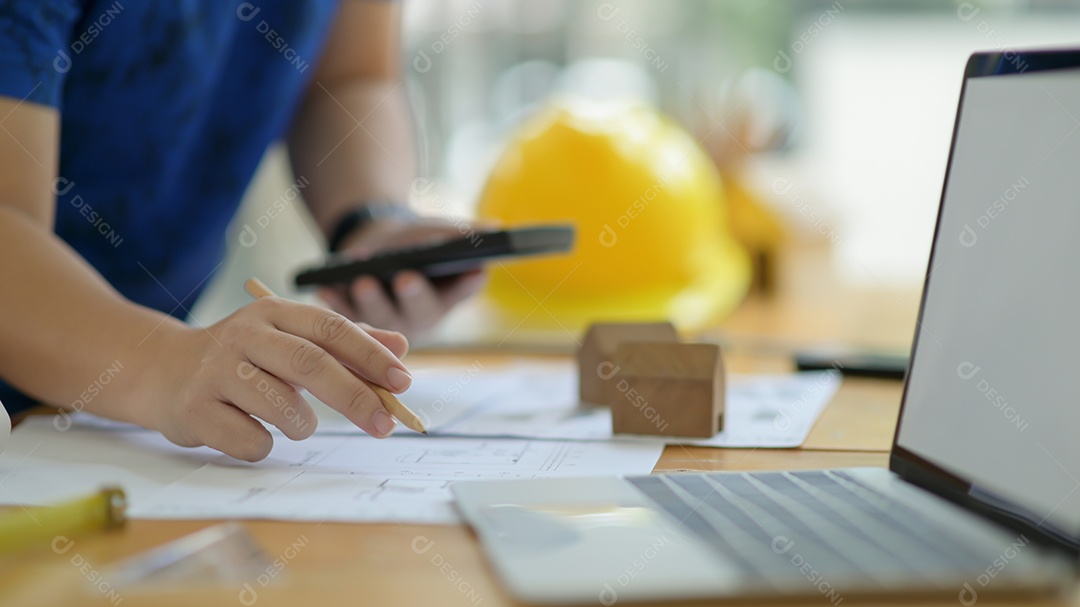 Designer está calculando e editando a planta da casa para apresentar ao cliente.