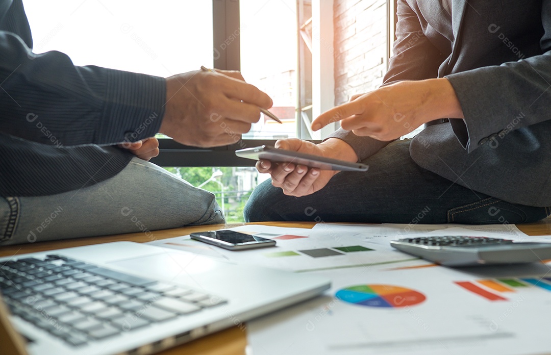 Conceitos de negócios, dois homem estão consultando um negócio, dois homens apontando para um tablet, laptop, gráficos, calculadora e telefone inteligente na mesa.