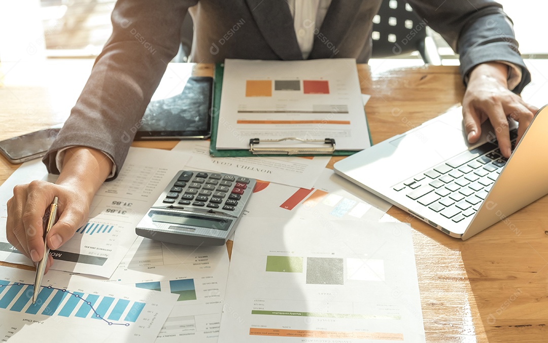 Conceitos de negócios, homem de terno estão usando uma caneta apontando no gráfico e outra mão usa laptop.