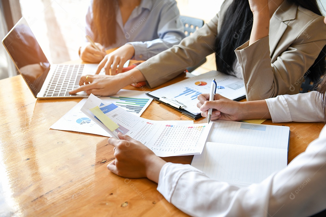 Três trabalhadores de escritório de menina estão trabalhando. Eles usam laptop e analisam gráficos.