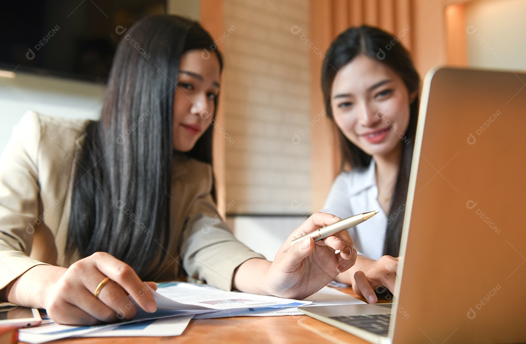 Trabalhador de escritório feminino está trabalhando no escritório. Eles usam um laptop e gráficos analíticos.