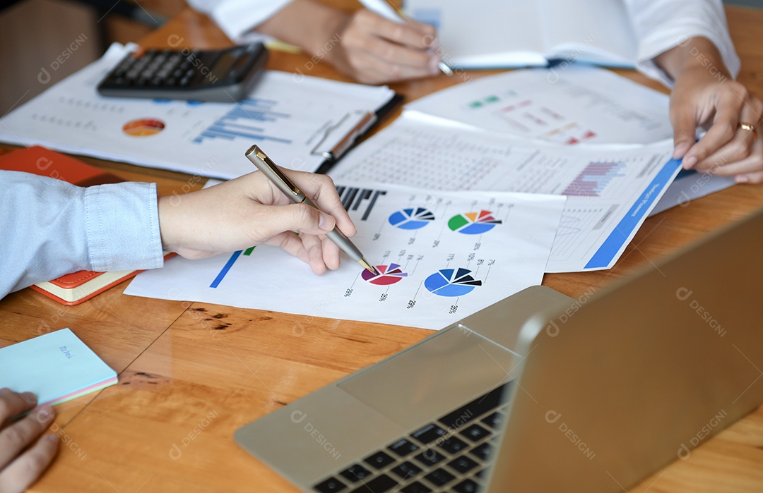 Trabalhadores de escritório de menina estão trabalhando. Eles usam uma calculadora e analisam gráficos.