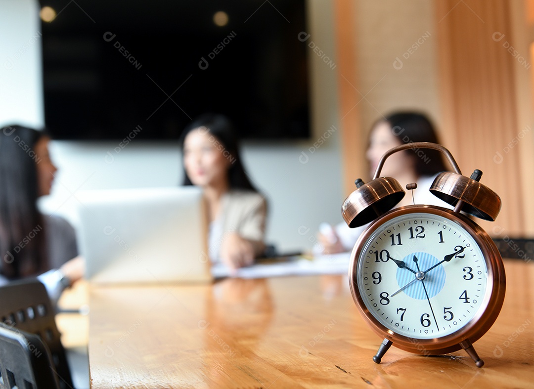 Assista na mesa na sala de reuniões. Trabalhadores de fundo desfocado estão sentados.