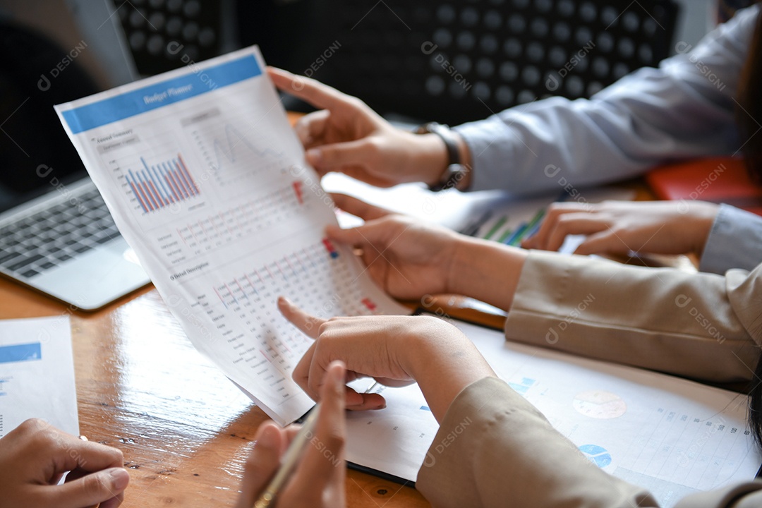 Funcionários estão analisando os dados. Eles usam as mãos apontando para gráficos.